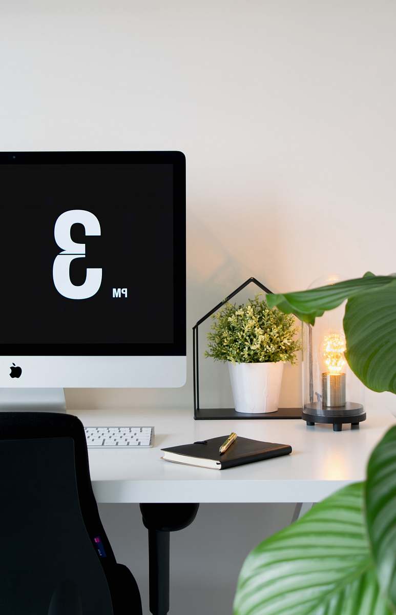 work silver iMac with Apple Magic keyboard on top of white table desk