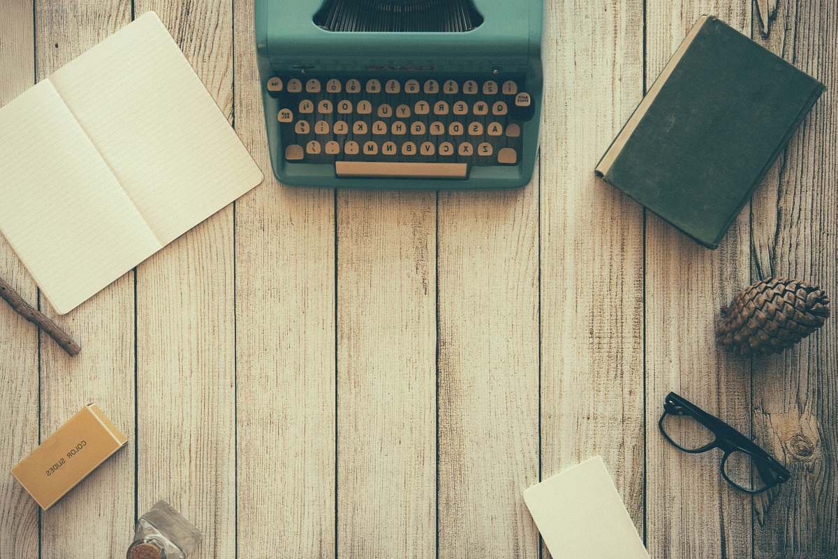 work vintage teal typewriter beside book desk
