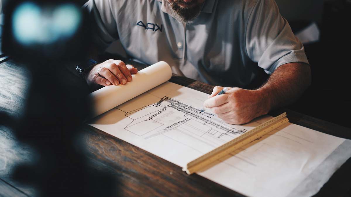 person An architect working on a draft with a pencil and ruler human
