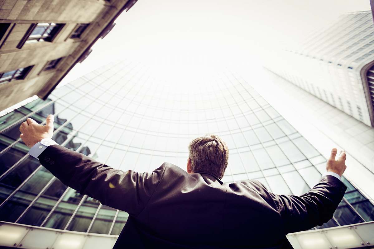human low-angle photography of man in the middle of buidligns person