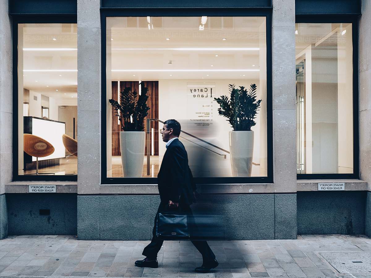 person man in black suit jacket in walking gesture window