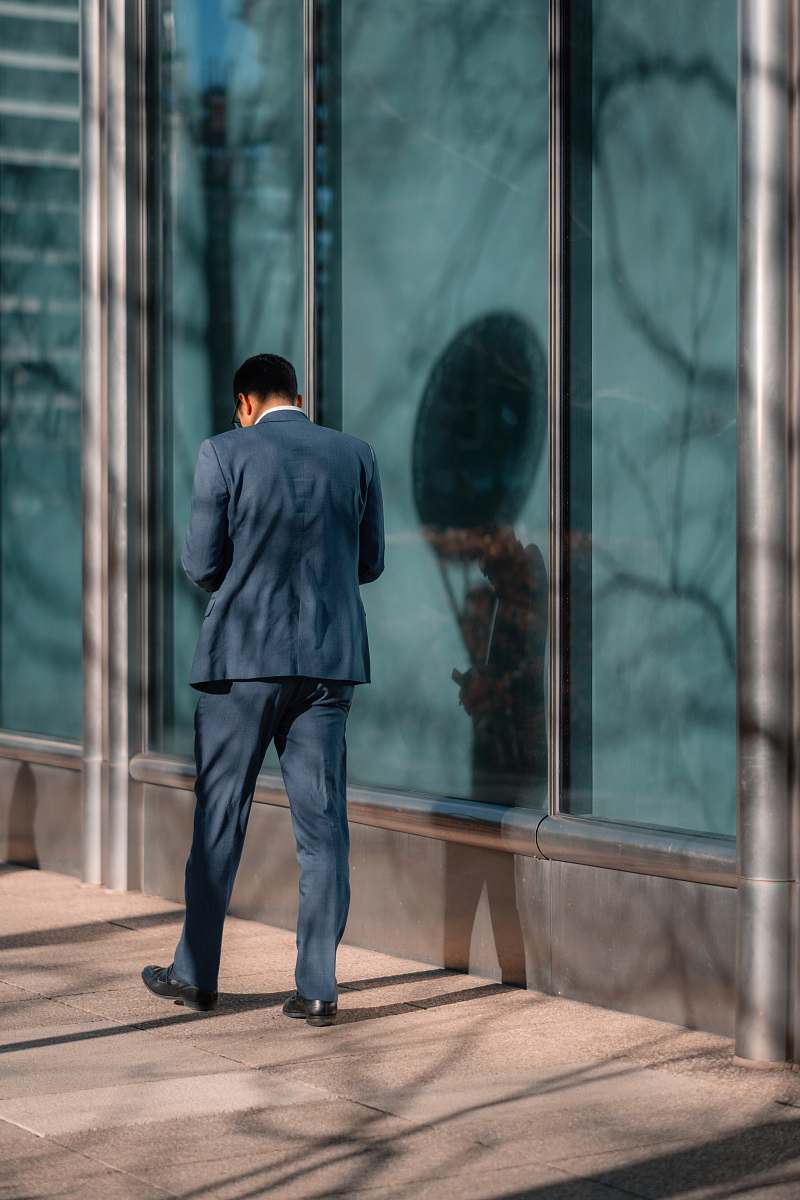 person man standing near glass wall human