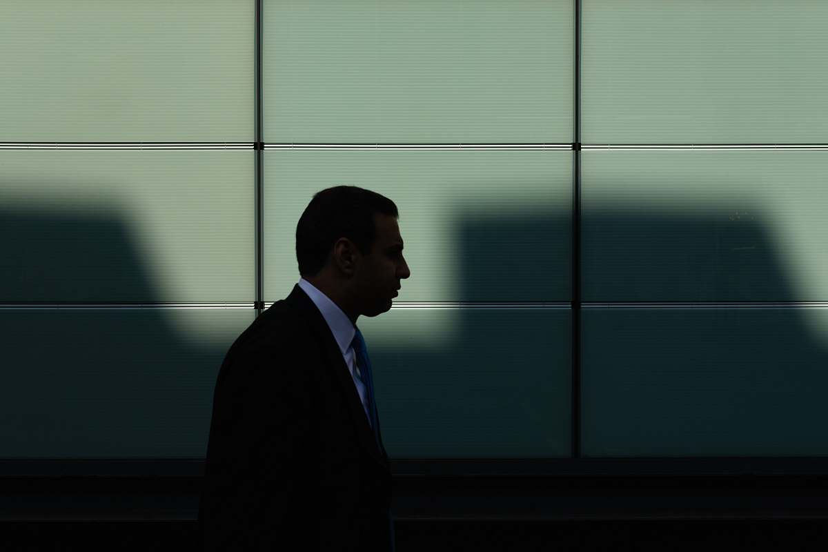 person man walking near gray concrete wall human