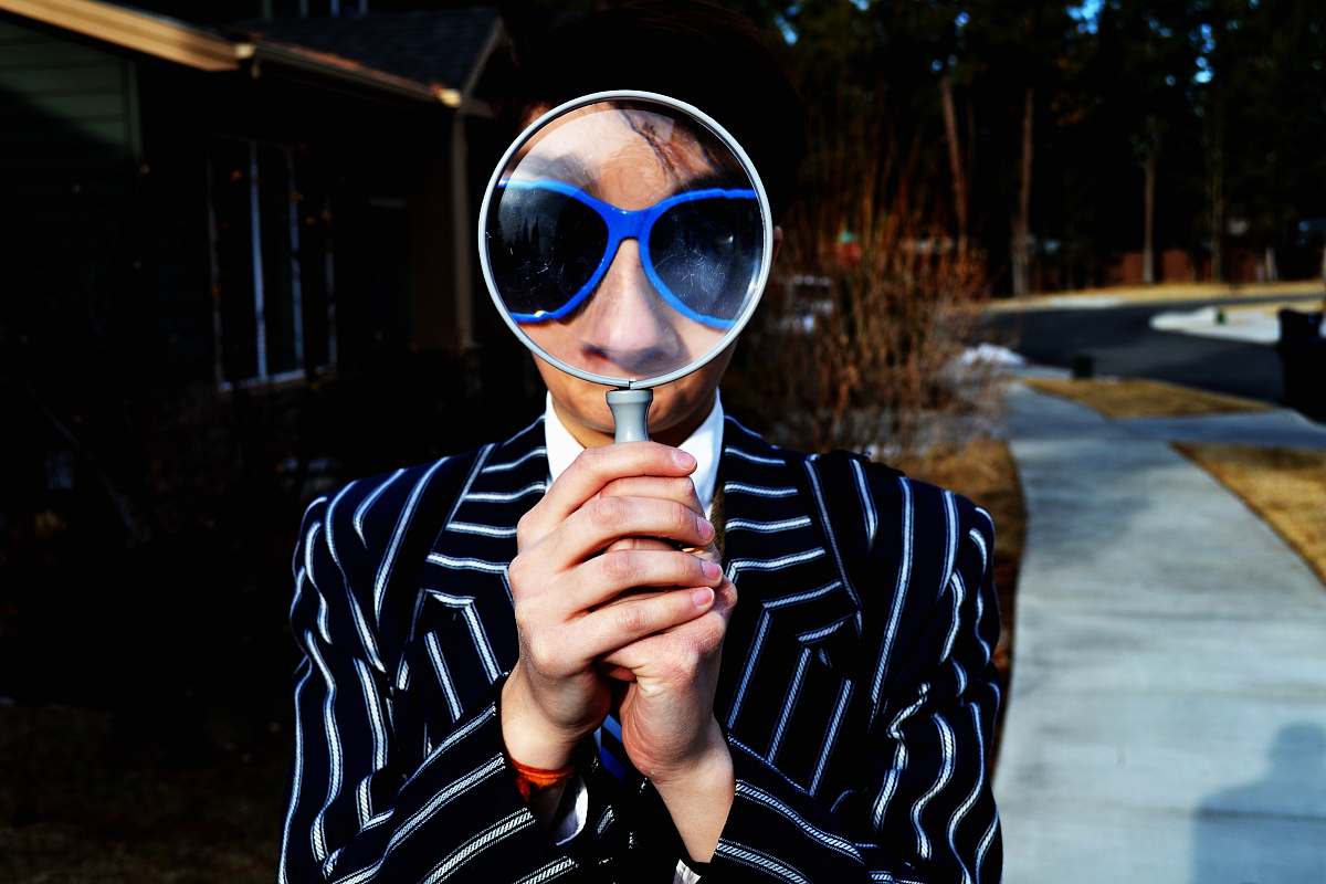 person person using magnifying glass enlarging the appearance of his nose and sunglasses magnifying glass
