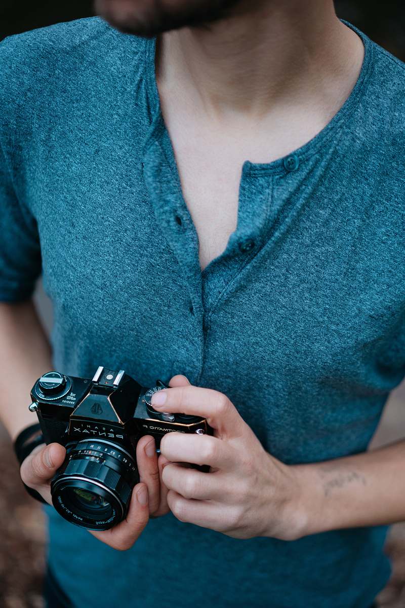 camera man holding Pentax SLR camera electronics