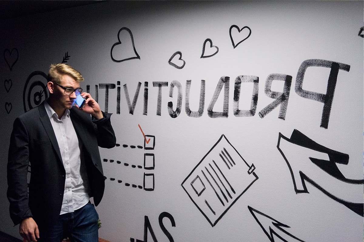 people man holding smartphone looking at productivity wall decor suit