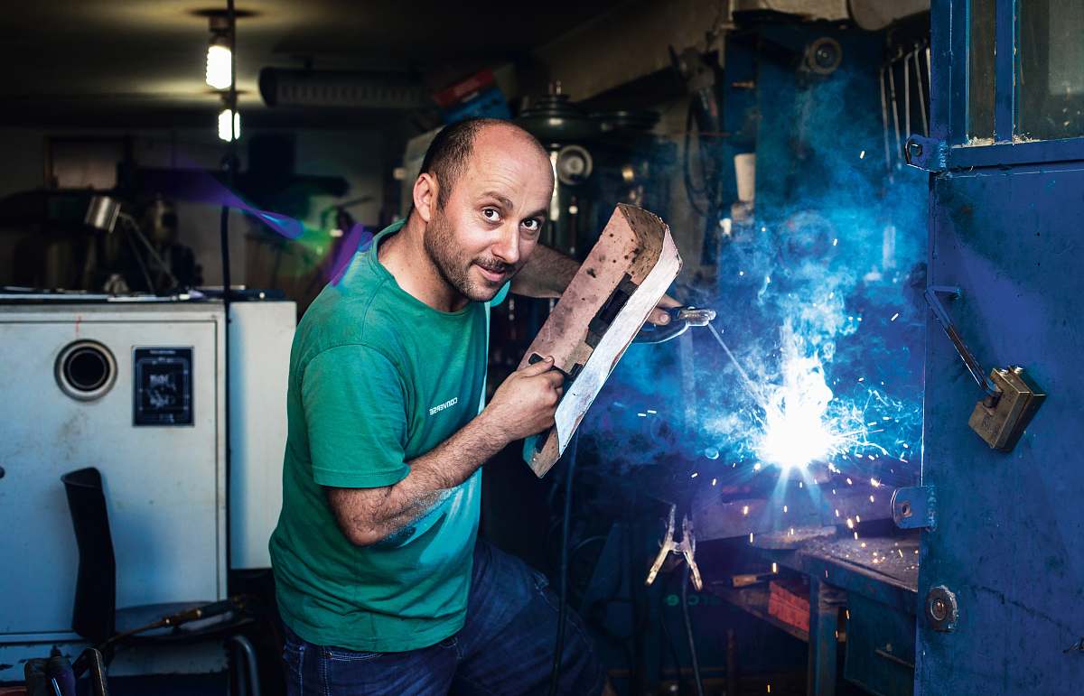 human man holding welding mask factory