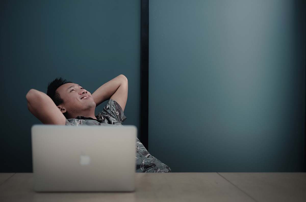 bandung man sitting on chair front of white MacBook indonesia