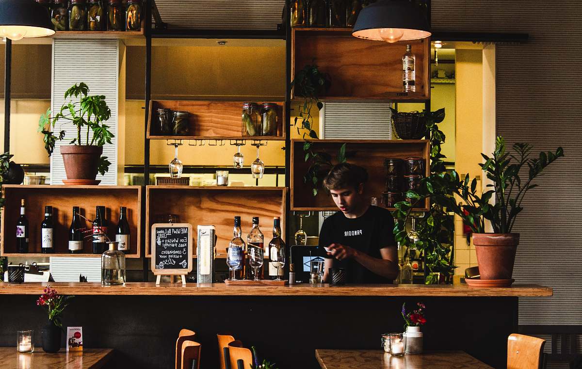 human man standing in front of bar table pub