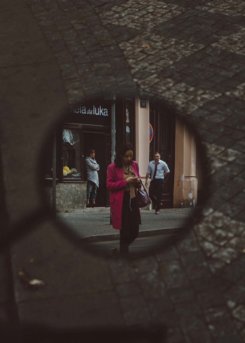 human mirror showing woman wearing pink coat walking on street people