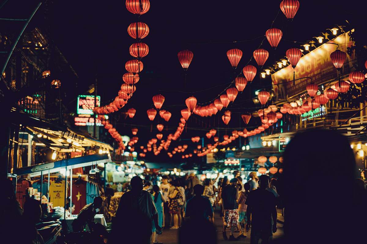 people people walking between food stalls under chinese lanterns vietnam