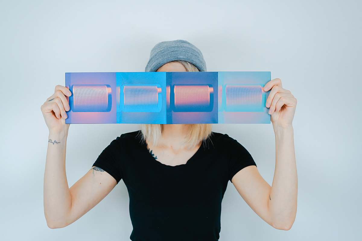 human person holding blue paper covering her face people