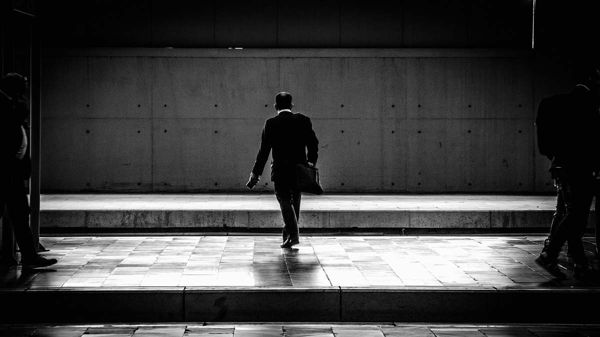 human person walking in the station black-and-white