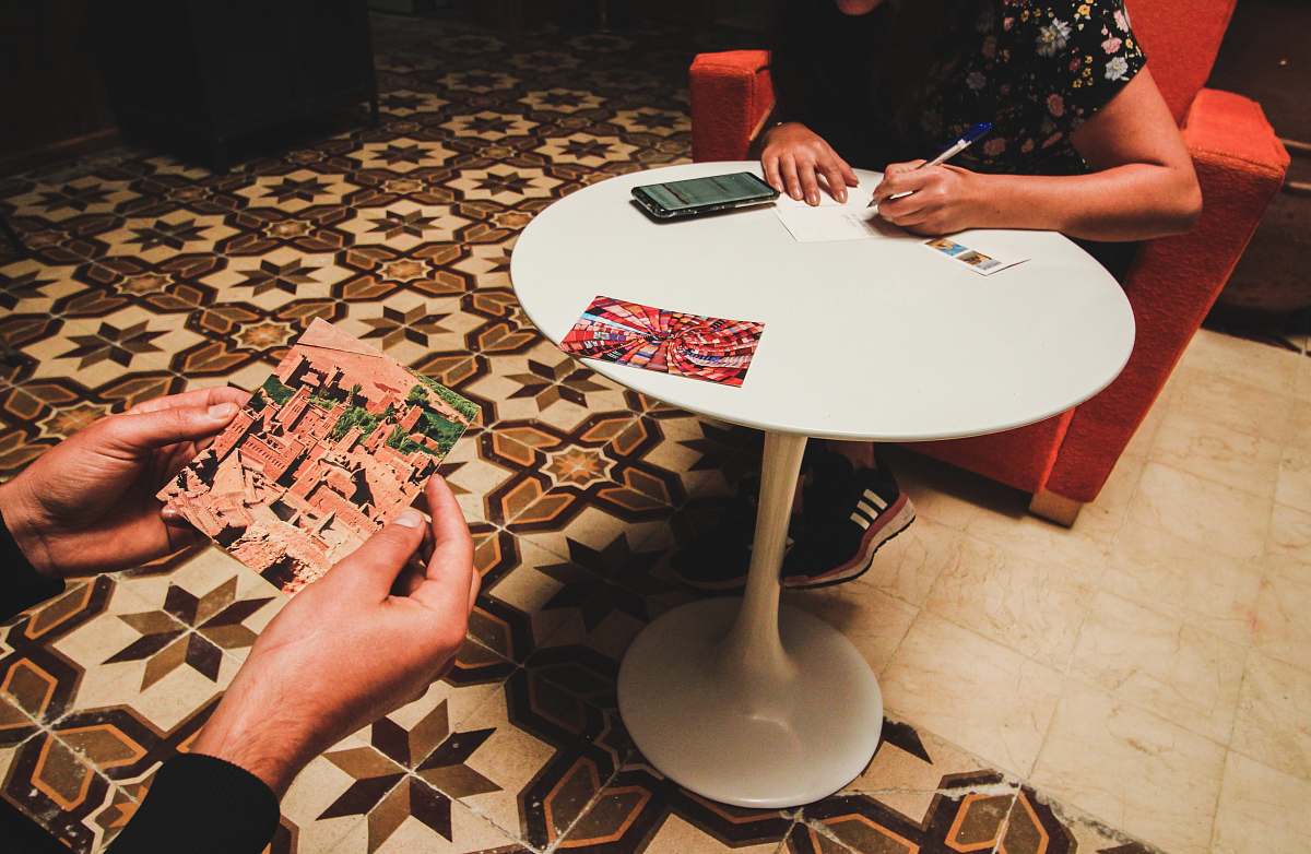 human person writing on white pedestal table flooring