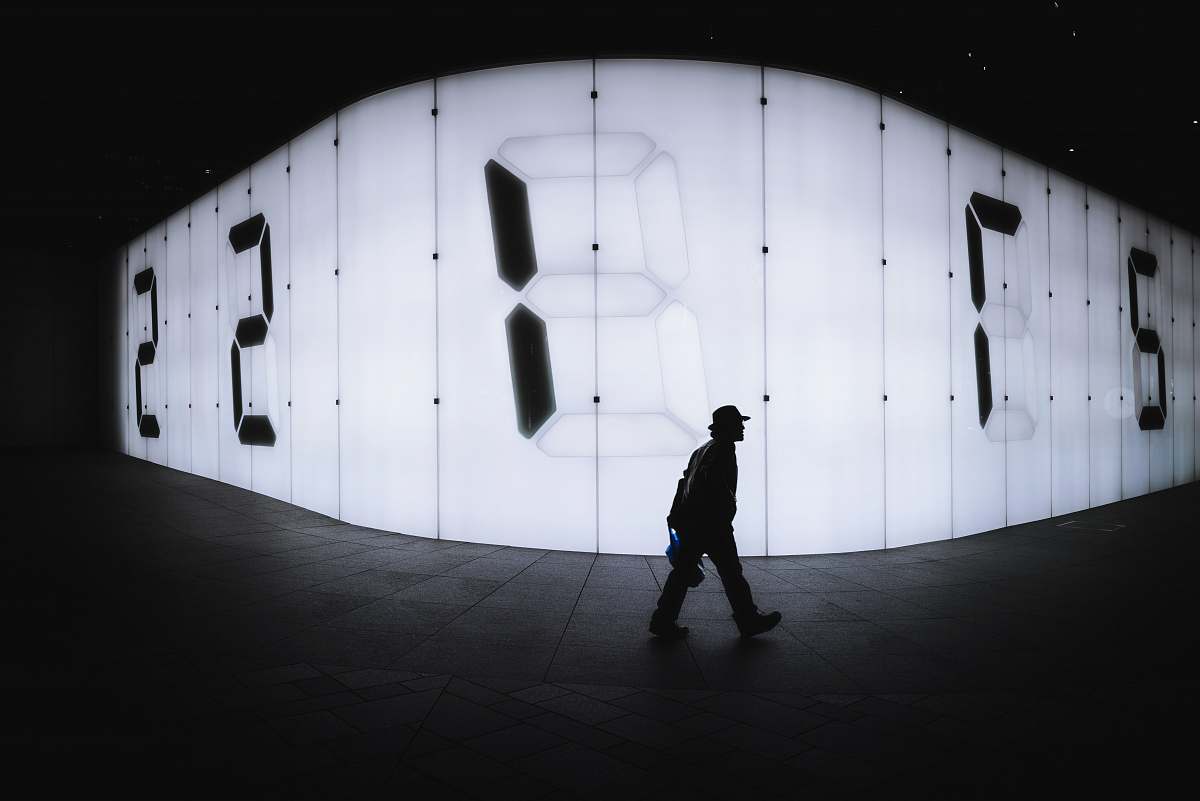 human photo of man walking near LED signage people