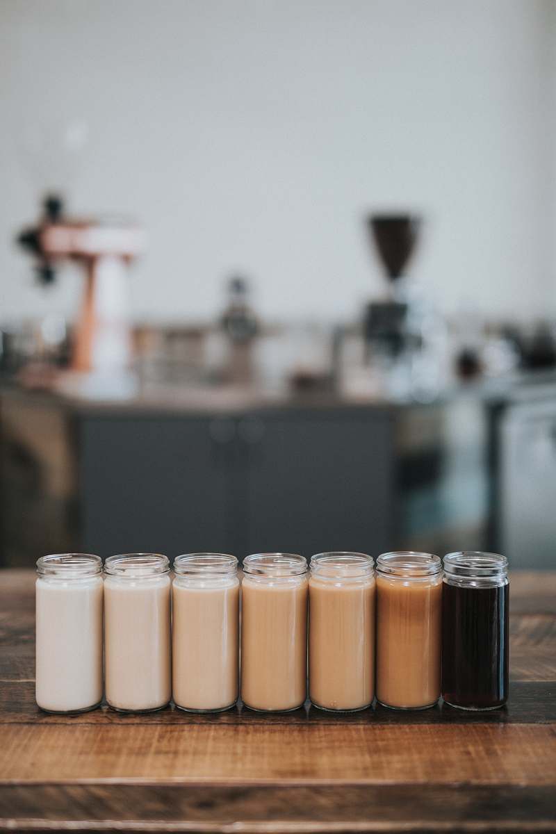 human selective focus photography of glass with liquid in it coffee