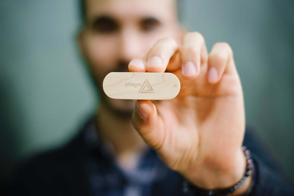 human selective focus photography of man in holding wooden ornament hand