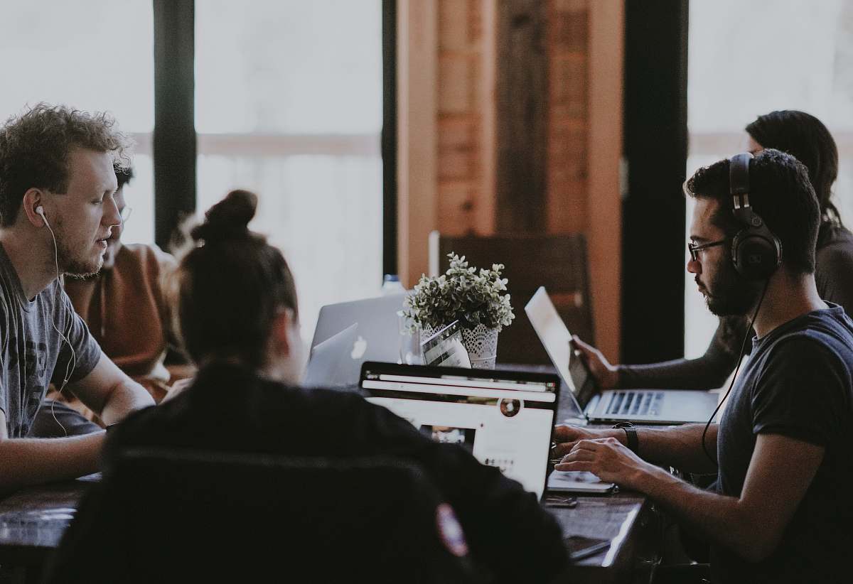 human selective focus photography of people sits in front of table inside room people