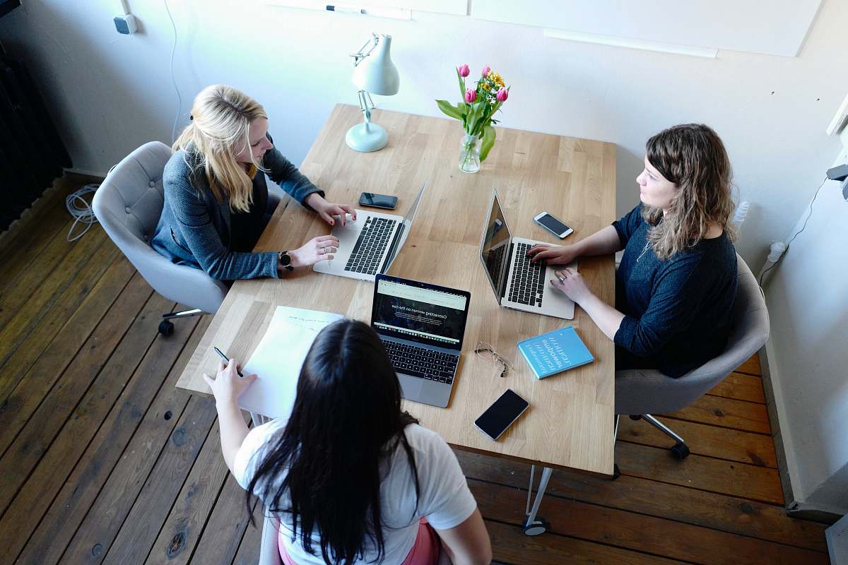 furniture three women sitting and facing each other table