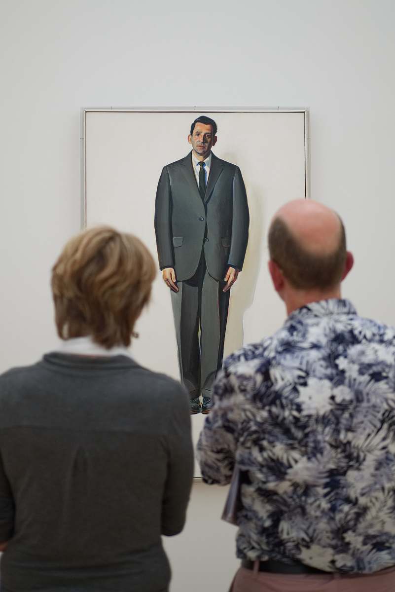 human two man standing in front of the painting people
