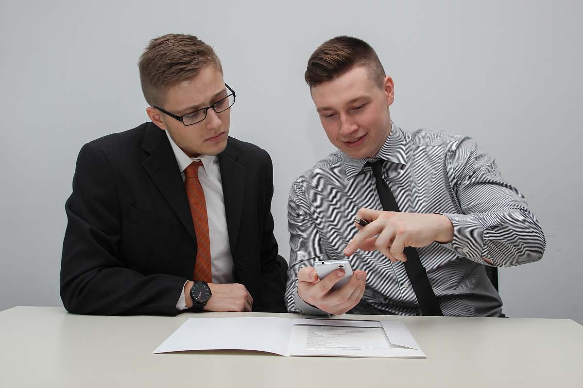 human two man watching smartphone sitting
