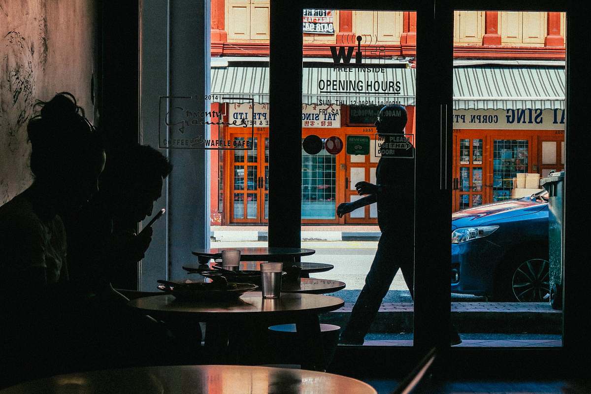 people two person inside building near glass door during daytime silhouette
