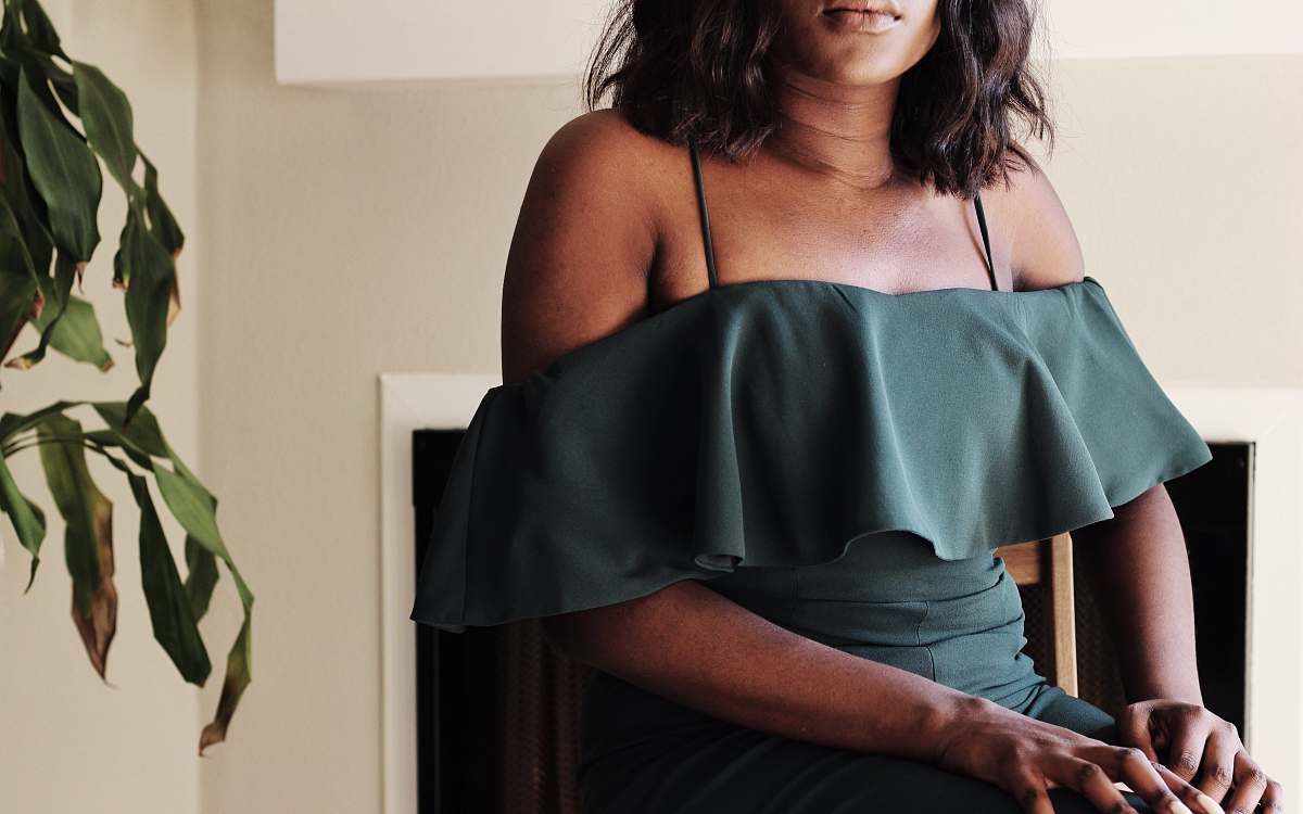 A serene scene featuring a human woman comfortably seated in a stylish chair, gracefully holding a green plant on her lap. This tranquil setting highlights the beauty of indoor greenery and can be used for lifestyle blogs, home decor inspiration, or wellness campaigns. The soft lighting enhances the atmosphere, creating an inviting space that embodies relaxation and harmony with nature.