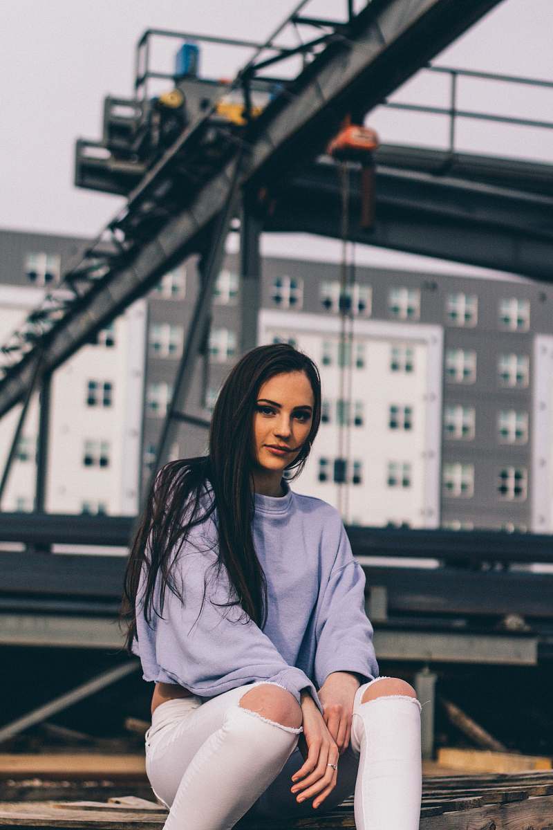 human woman sitting on brown concrete while taking selfie picture people