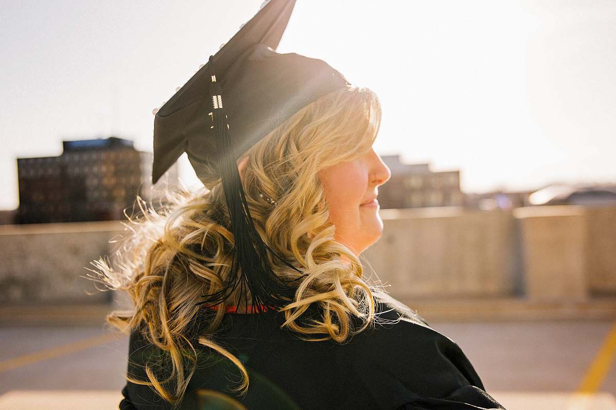 people woman wearing academic regalia during daytime woman