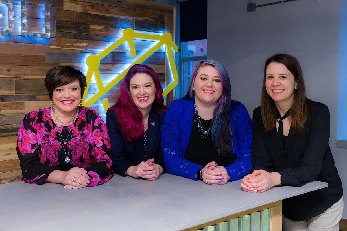 This vibrant image showcases three diverse women seated at a stylish counter, each dressed in an array of colorful cardigans. The cozy atmosphere invites creativity and warmth, making it perfect for lifestyle blogs, fashion websites, or articles focused on friendship and diversity. The striking colors and relaxed setting highlight a sense of community and personal style, ideal for any project that celebrates individuality and togetherness.