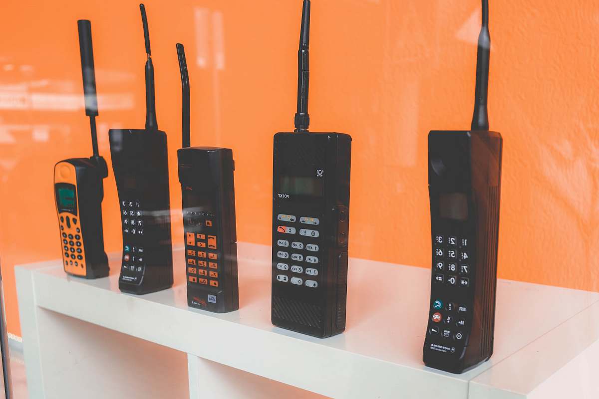 electronics five assorted-brand wireless phones on desk cell phone