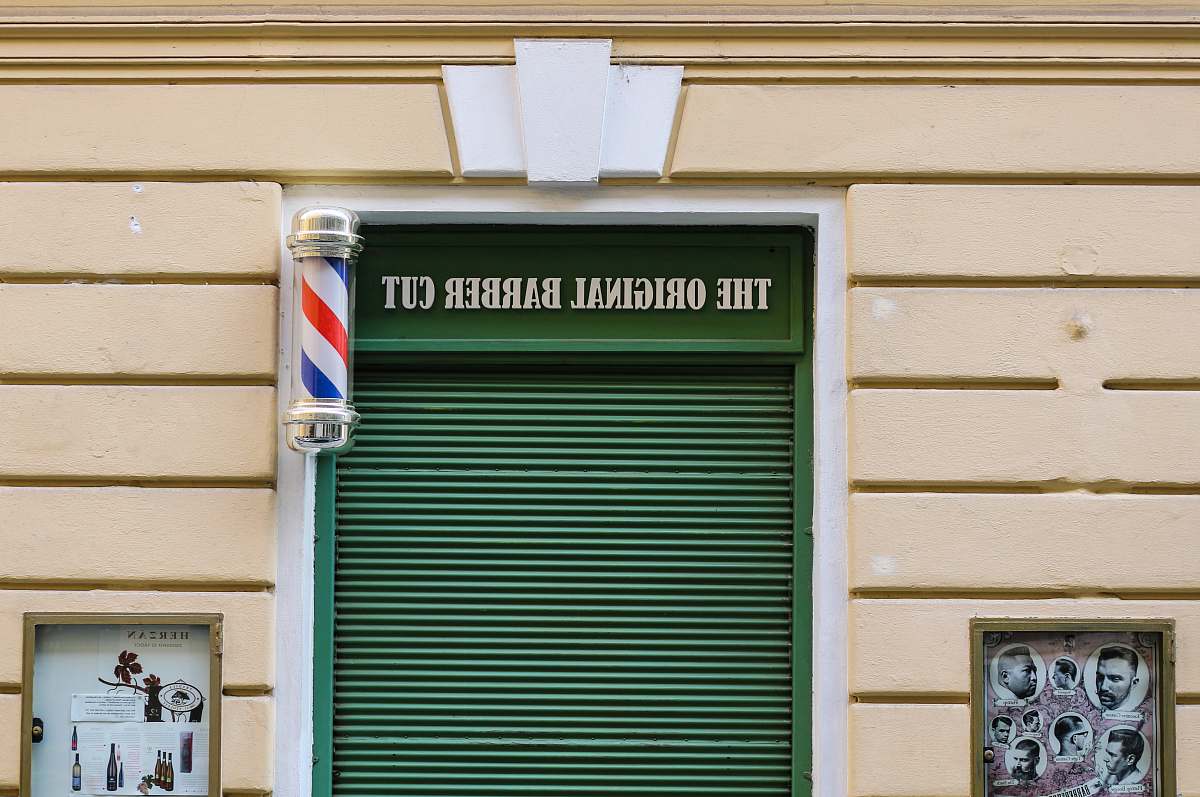 czechia beige building with The Original Barber Cut sign entrance