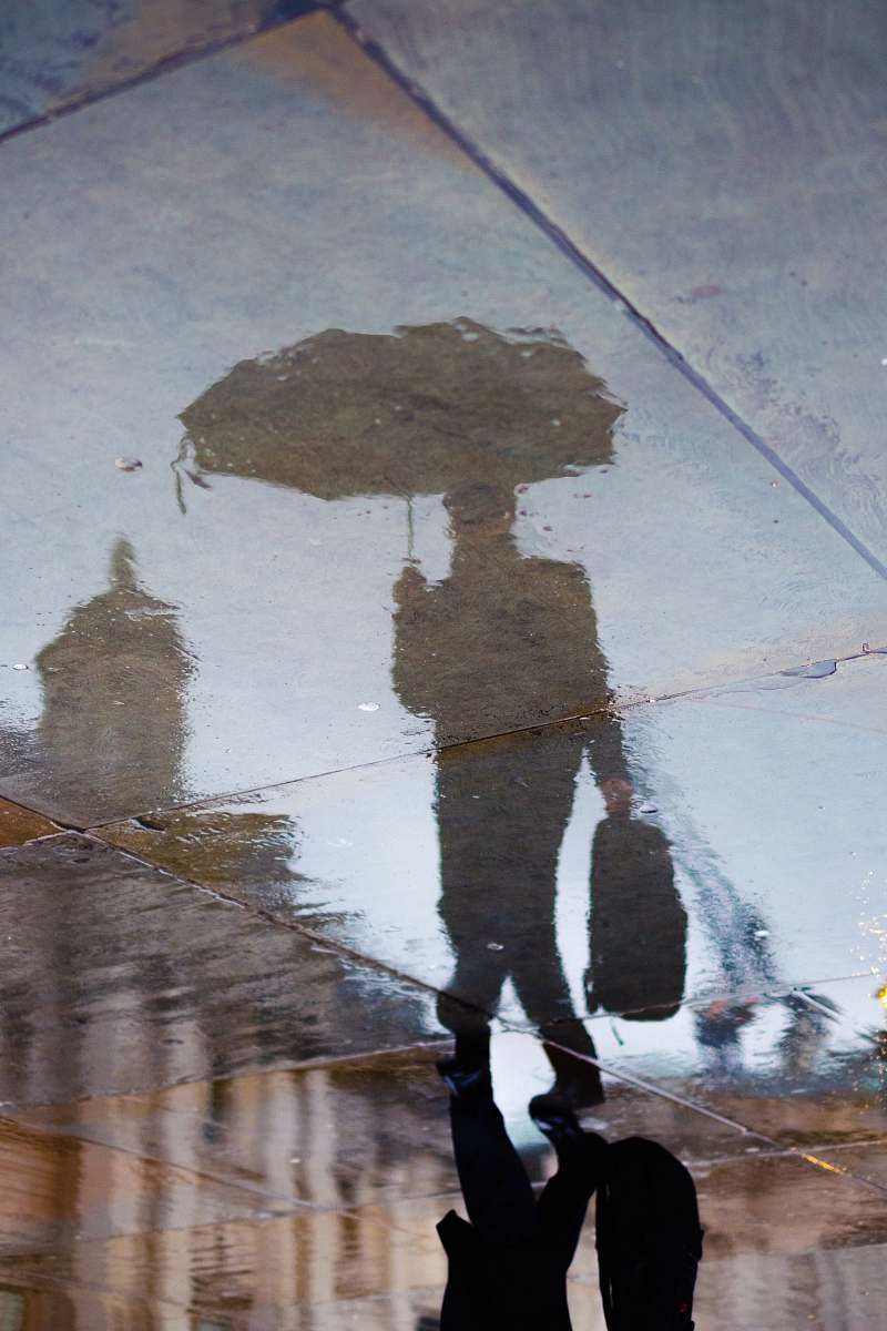 london reflection of person holding bag and umbrella smart