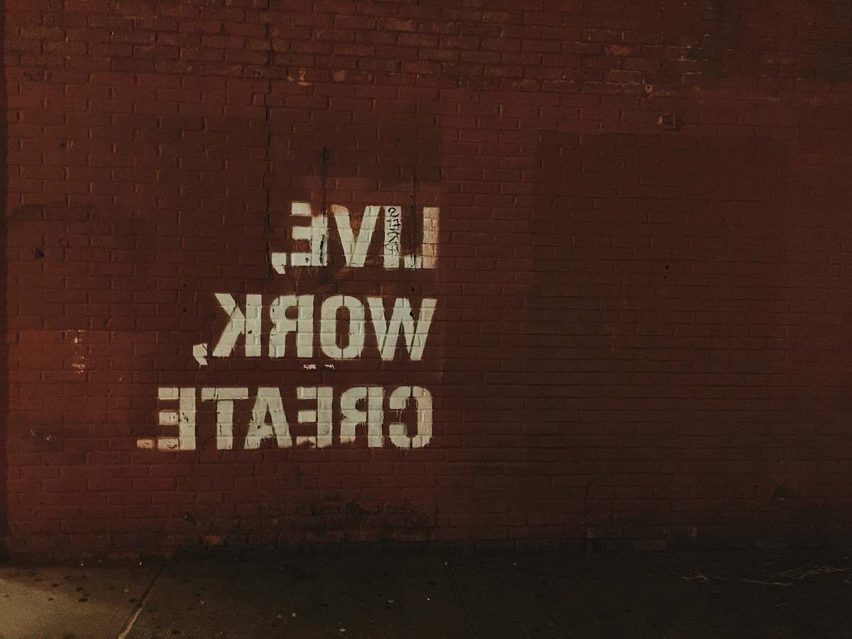 inspiration red brick wall with live, work, create. quote words