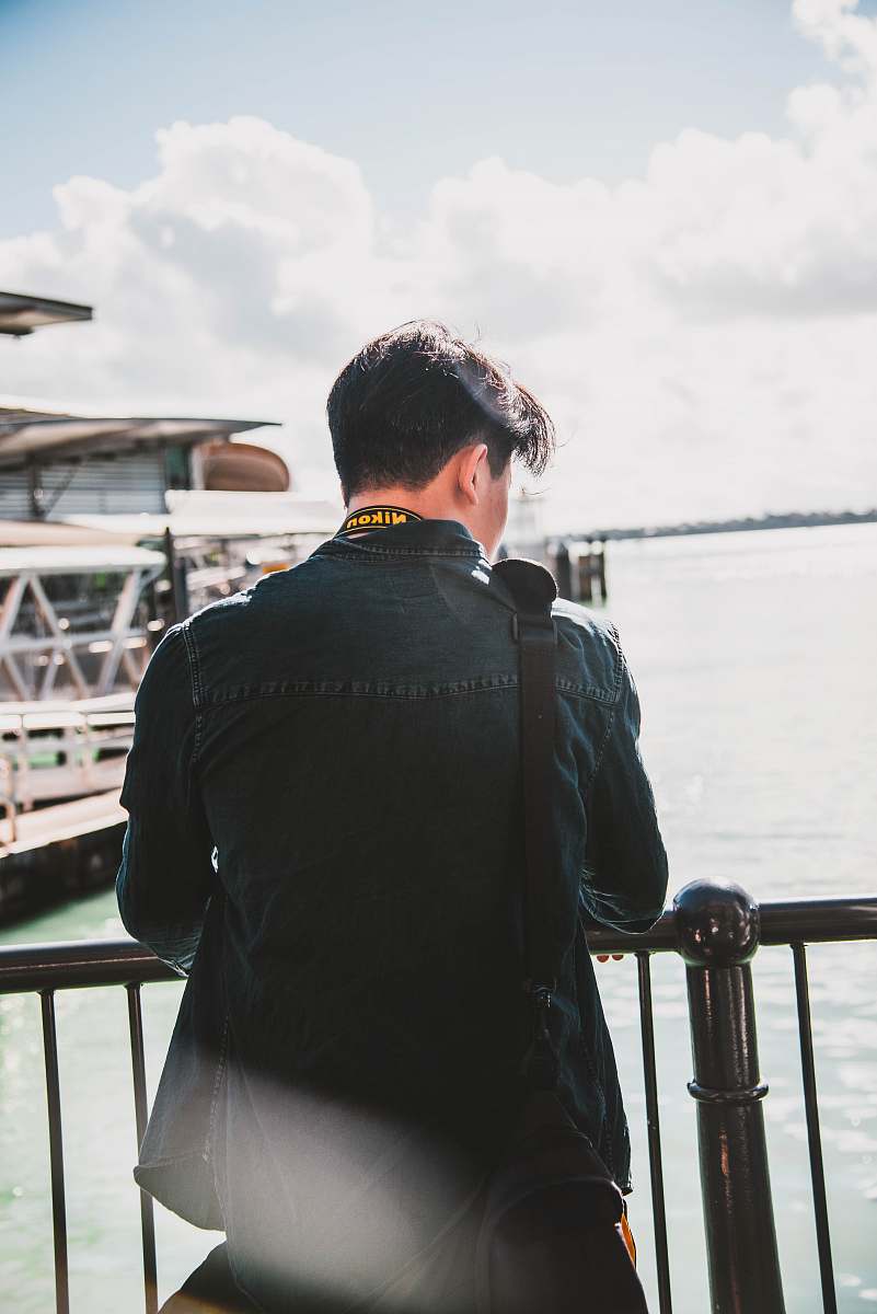 banister man looking at sea handrail