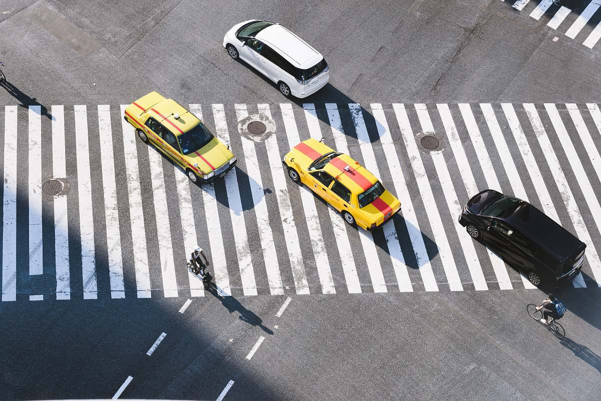 asphalt aerial photo of four vehicles on road at daytime tarmac