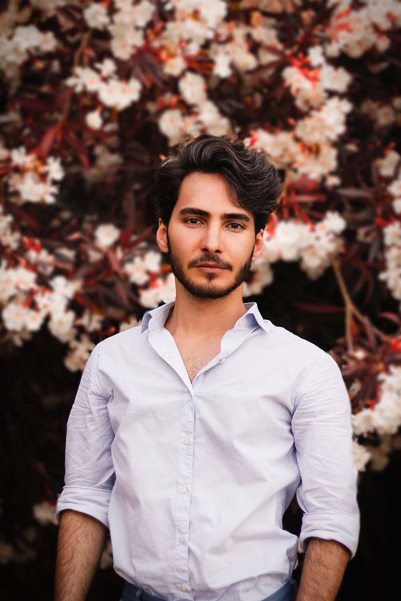apparel man wearing white button-up dress shirt near white petaled flower tree clothing