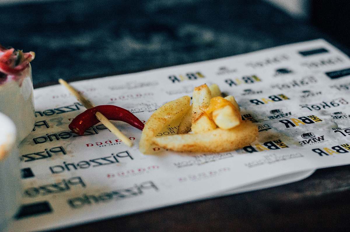 food French fries and a hot chili pepper at an Indian Restaurant cocktail stick