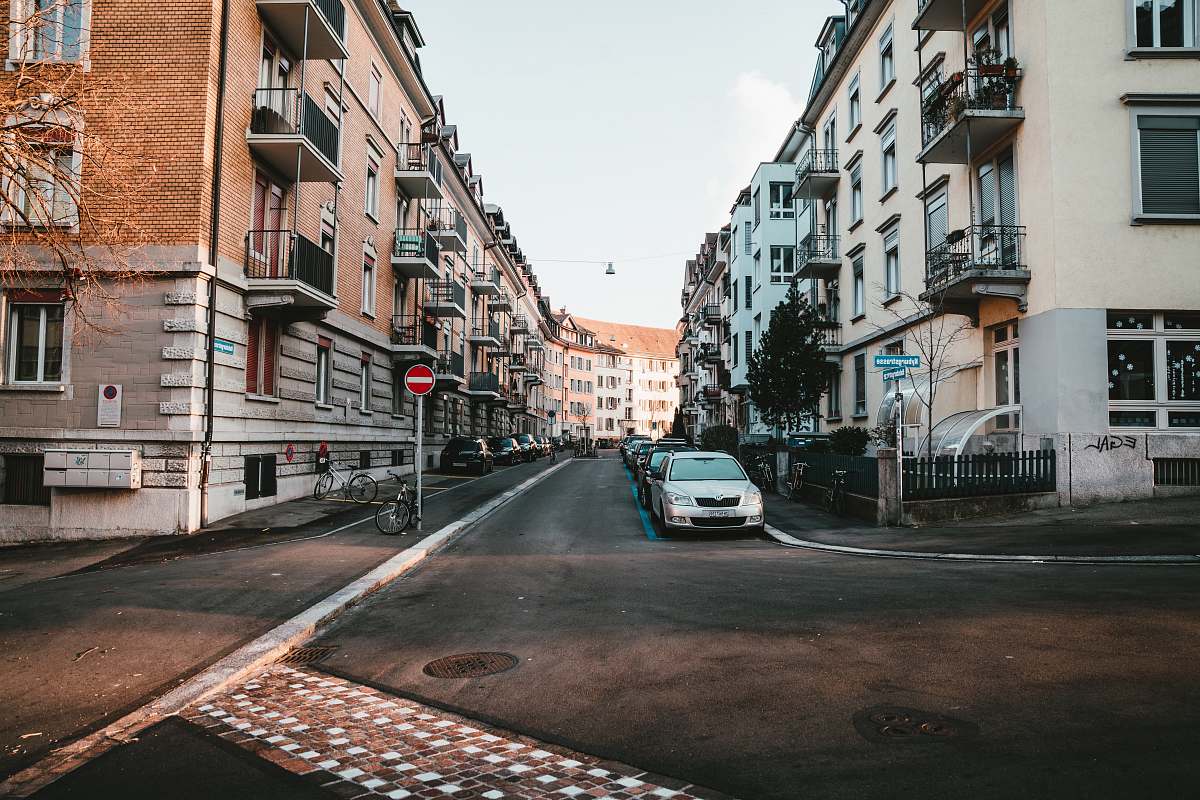 road brown and white concrete buildings car