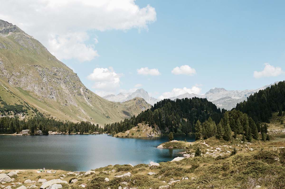 nature body of water near trees and mountain at daytime mountain
