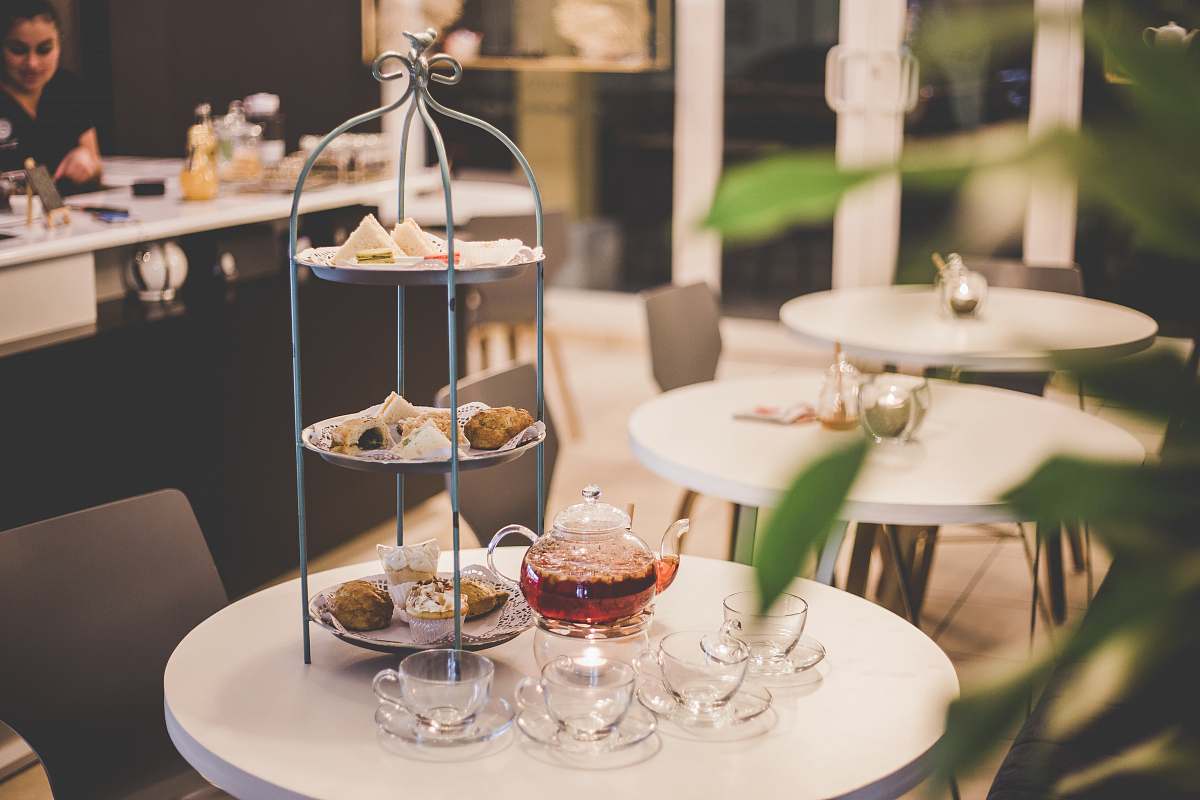 furniture tea set beside gray 3-tier rack on round white table dining table