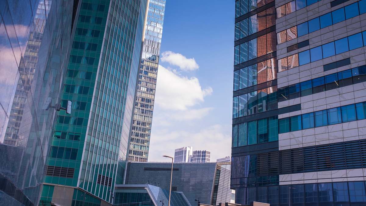 This breathtaking architectural photograph showcases a vibrant city skyline dominated by towering high-rise buildings. Captured from an elevated perspective, the image reveals the intricate designs and modern aesthetics of urban architecture, perfect for use in real estate marketing, urban development presentations, or lifestyle blogs. The dynamic composition highlights the bustling life of the city, making it an ideal choice for projects focused on urban living and architectural innovation.
