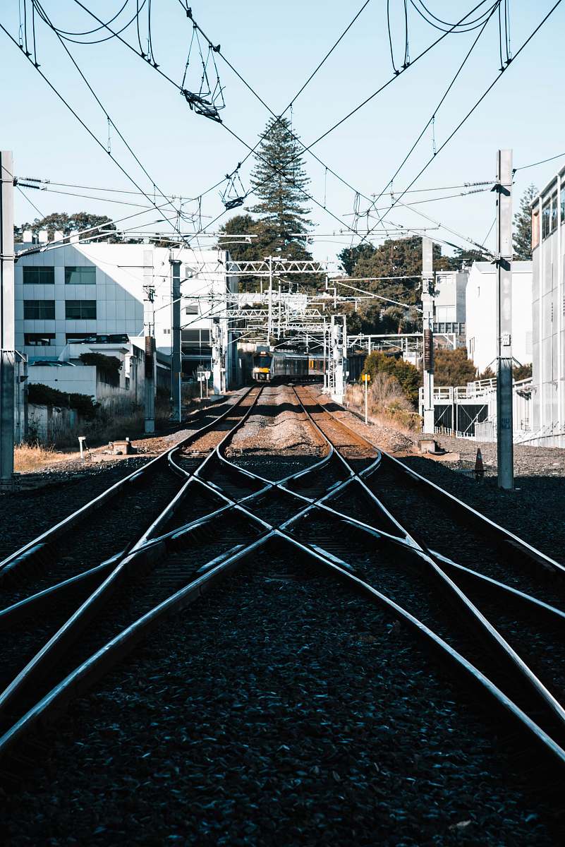 rail train tracks in the city during daytime railway