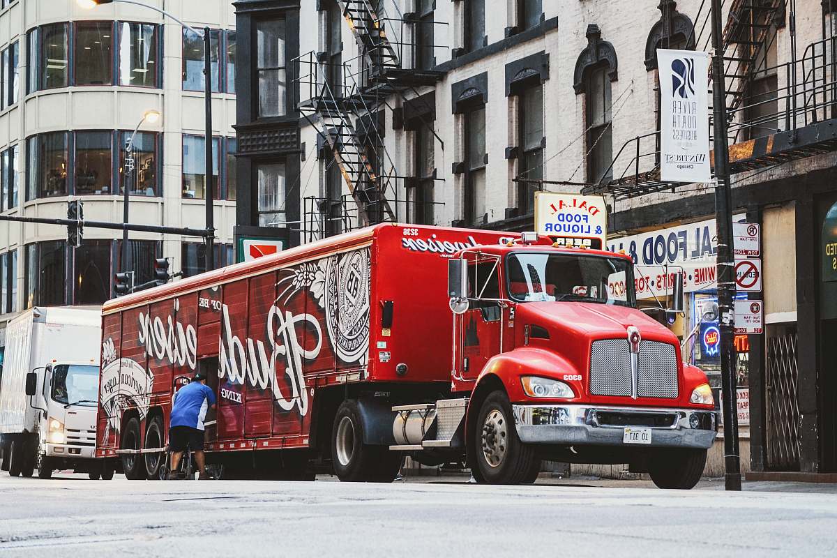 chicago man near red Budweiser trailer truck parked near concrete building during daytime vehicle