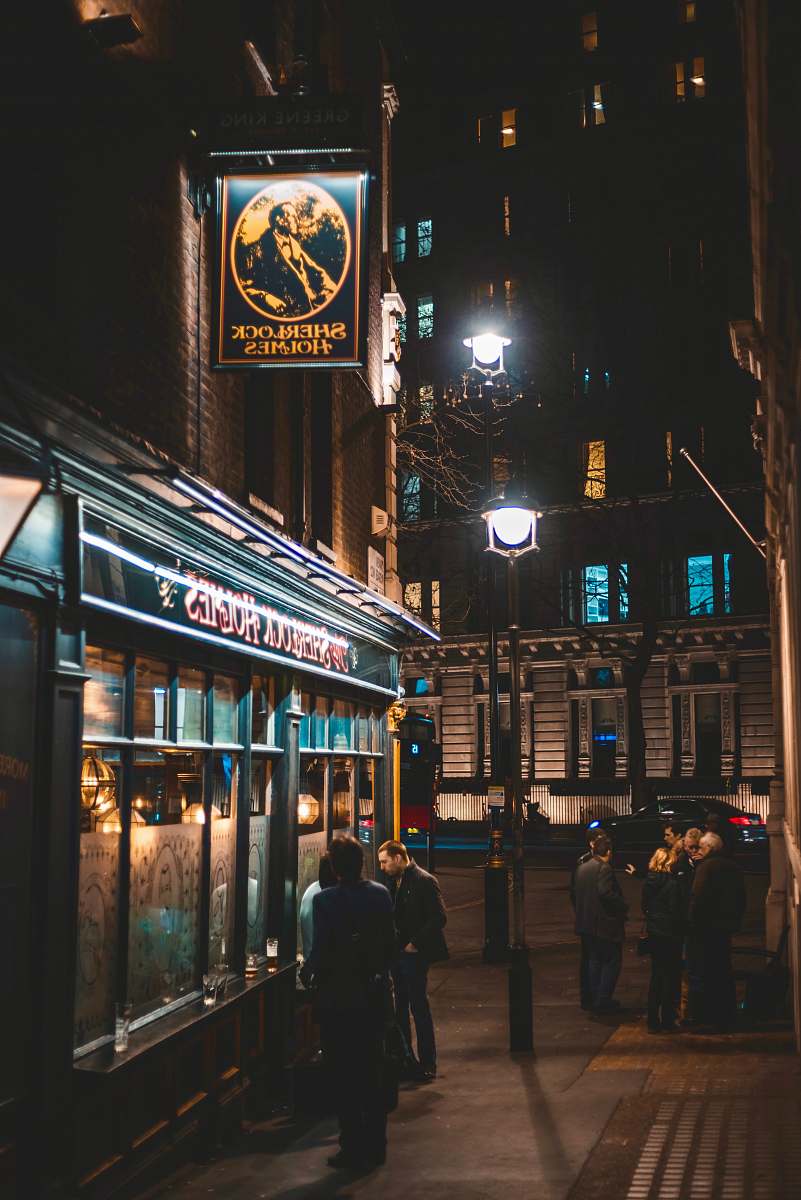 town people standing near building at night street