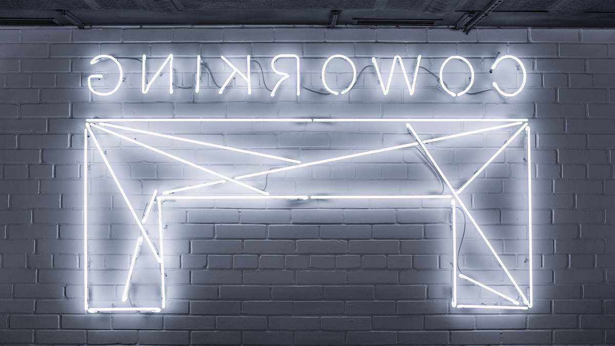 neon closeup photo of Co Working neon light sign grey