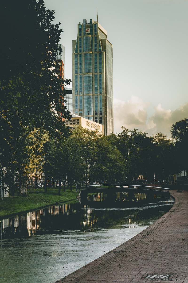 Discover a tranquil scene featuring a picturesque canal nestled within an urban landscape, framed by vibrant greenery. This outdoor image captures the essence of city life harmoniously blended with nature, making it perfect for use in travel blogs, environmental articles, or urban planning projects. Whether illustrating the importance of green spaces in cities or showcasing serene outdoor vistas, this captivating photograph invites a sense of peace and relaxation.