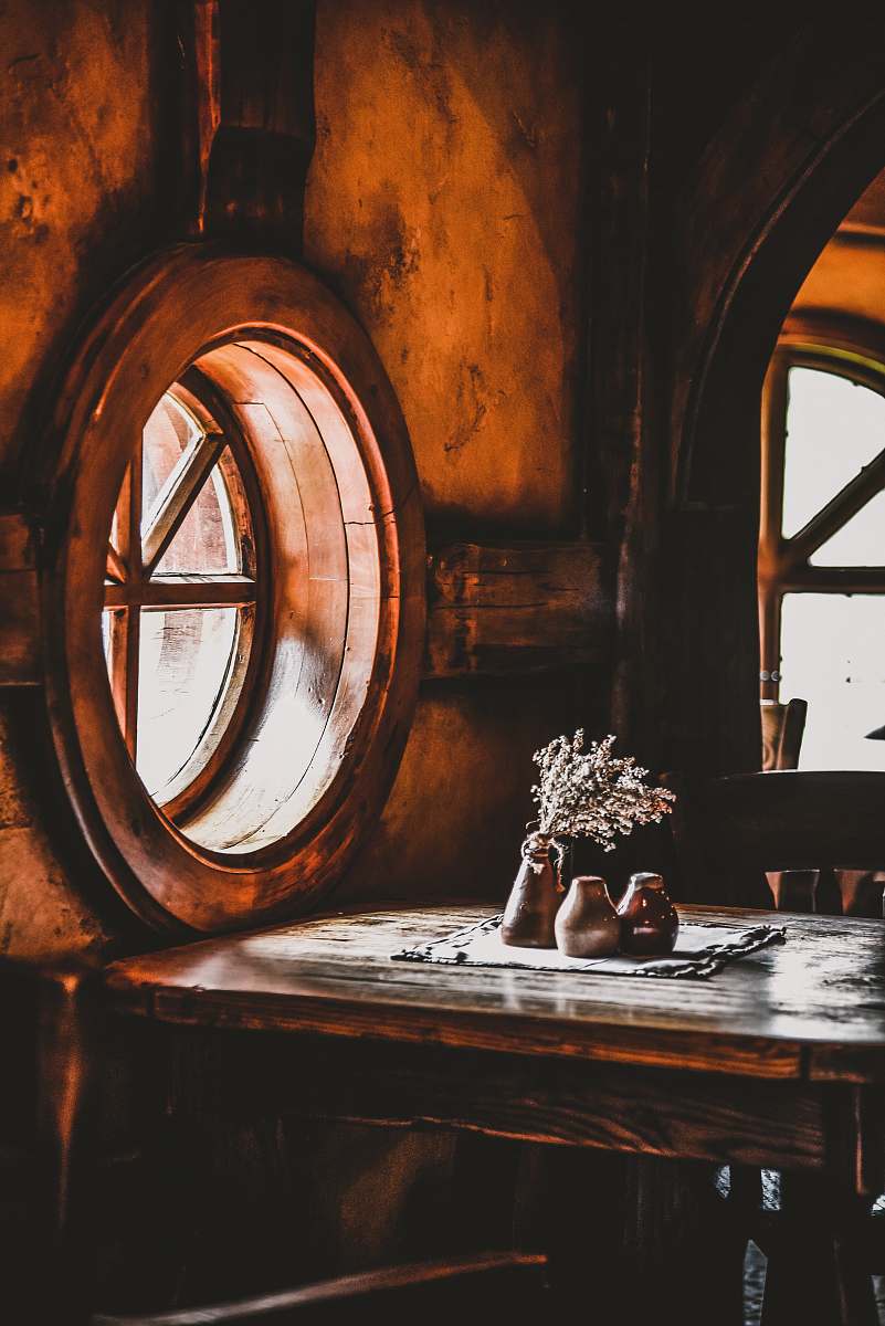 brown flower vase beside window porthole