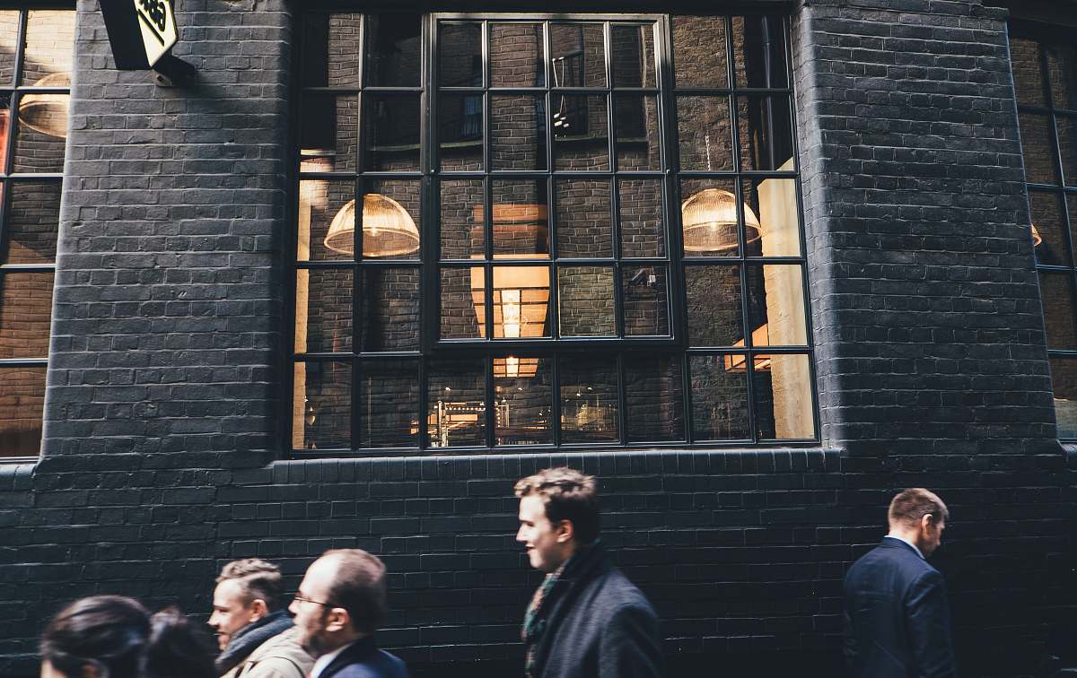 light people standing beside black building person