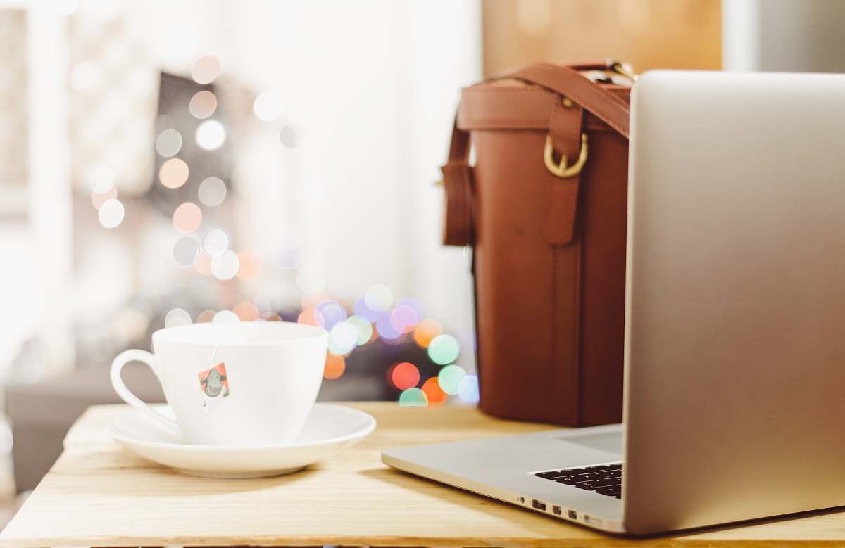 coffee gray laptop beside teacup and bg cup